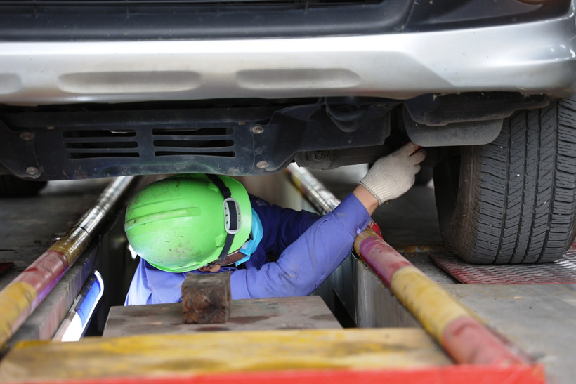 Nhân viên đăng kiểm thực hiện quy trình kiểm định xe cơ giới. (Ảnh: Minh Hiếu/Vietnam+)