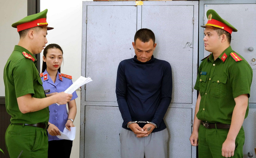 Công an đọc lệnh bắt tạm giam đối tượng Nguyễn Văn Hào. (Ảnh: Công Tường/TTXVN)