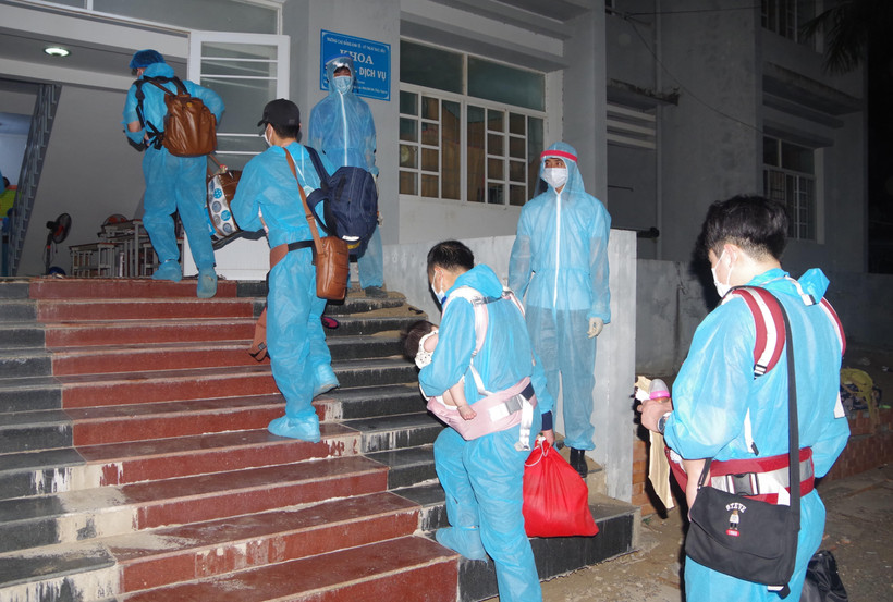 Công dân Việt Nam từ nước ngoài trở về được các nhân viên y tế hướng dẫn vào khu cách ly. (Ảnh: Chanh Đa/TTXVN)