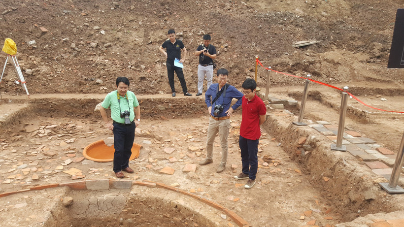 Các đại biểu tìm hiểu các hố khai quật tại khu vực điện Kính Thiên. (Ảnh: Đinh Thuận/TTXVN)