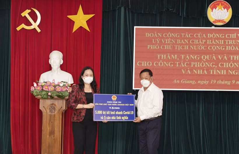 Phó Chủ tịch nước Võ Thị Ánh Xuân trao bảng tượng trưng 5.000 bộ kit test nhanh COVID-19 và 5 căn nhà tình nghĩa cho tỉnh An Giang. (Ảnh: Công Mạo/TTXVN)