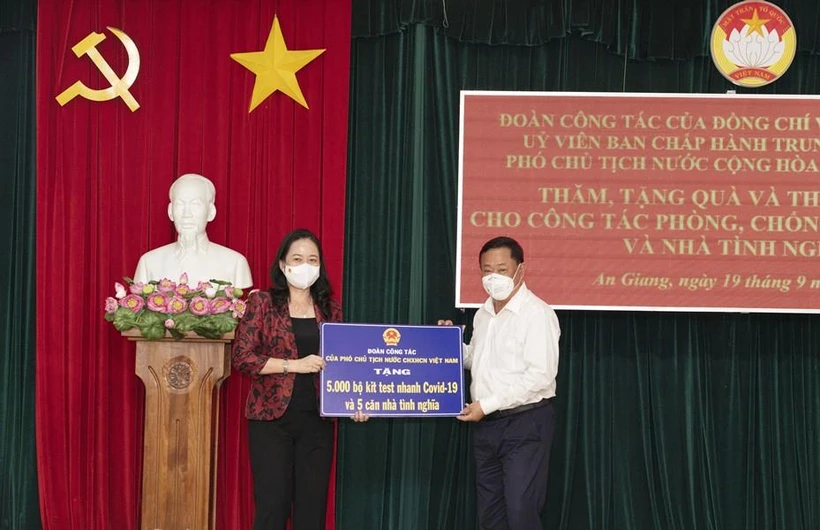 Phó Chủ tịch nước Võ Thị Ánh Xuân trao bảng tượng trưng 5.000 bộ kit test nhanh COVID-19 và 5 căn nhà tình nghĩa cho tỉnh An Giang. (Ảnh: Công Mạo/TTXVN)