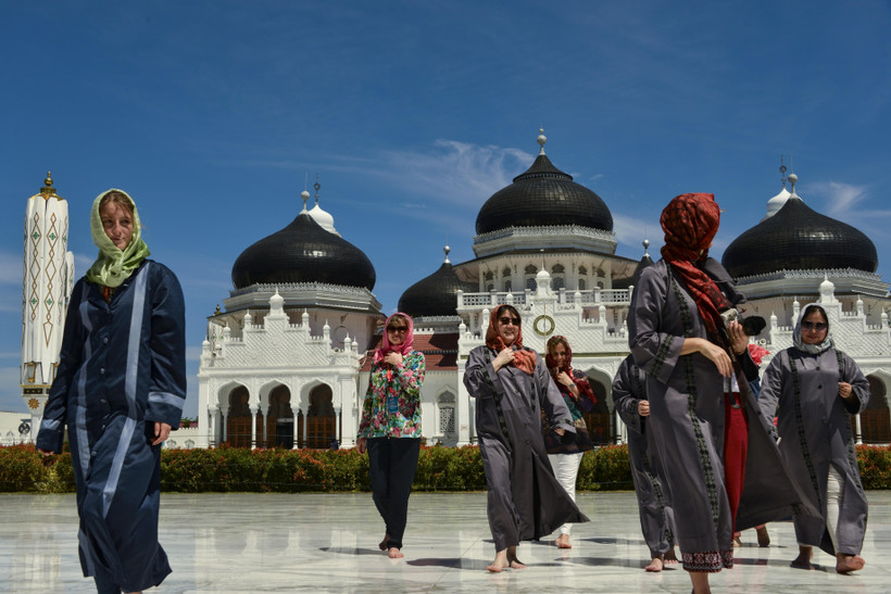 Khách du lịch nước ngoài thăm nhà thờ Hồi giáo Baiturrahman ở Banda Aceh, Indonesia. (Ảnh: AFP/TTXVN)