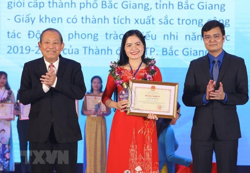 Phó Thủ tướng Thường trực Trương Hòa Bình (bên trái) và Bí thư Trung ương Đoàn, Chủ tịch Trung ương Hội Sinh viên Việt Nam Bùi Quang Huy trao Bằng khen và biểu trưng, tuyên dương 'Nhà giáo trẻ tiêu biểu' cấp Trung ương lần thứ II.(Ảnh: Văn Điệp/TTXVN)
