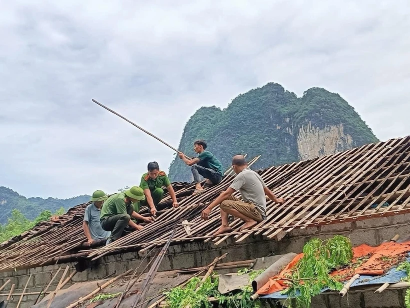 Lực lượng chức năng huyện Hạ Lang, tỉnh Cao Bằng giúp người dân khắc hậu quả của dông lốc. (Ảnh: TTXVN phát)