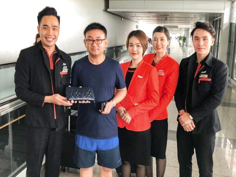 Tổ tiếp viên hãng hàng không Jetstar Pacific trao trả tài sản khách bỏ quên trên máy bay. (Ảnh: CTV/Vietnam+)