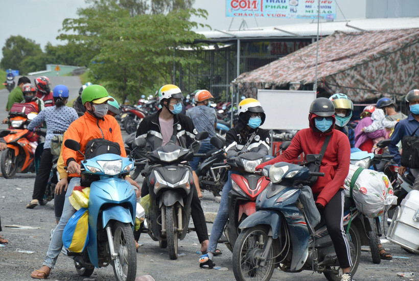 Người dân Đồng Tháp về từ các tỉnh tại điểm tiếp nhận, xét nghiệm sàng lọc SARS-CoV-2 trên Quốc lộ N2 (xã Đốc Binh Kiều, huyện Tháp Mười). (Ảnh: Nhựt An/TTXVN)