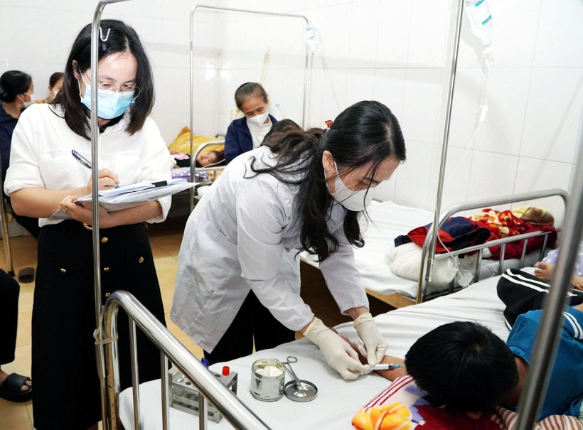 Cán bộ Trung tâm Kiểm soát bệnh tật lấy mẫu máu xét nghiệm. (Ảnh: Công Tường/TTXVN)