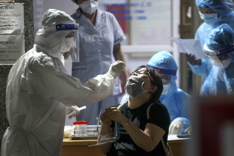 Nhân viên y tế lấy mẫu xét nghiệm COVID-19 cho những người có nguy cơ mắc COVID-19 tại Bệnh viện Phổi Hà Nội. (Ảnh: Tuấn Đức/TTXVN)