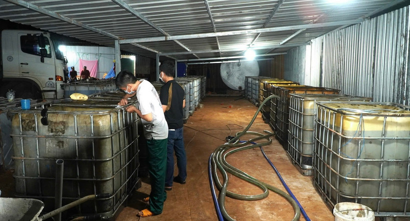 Lực lượng chức năng tiến hành niêm phong các thùng chứa dầu nhớt, hóa chất ngay trong đêm. (Ảnh: TTXVN phát)