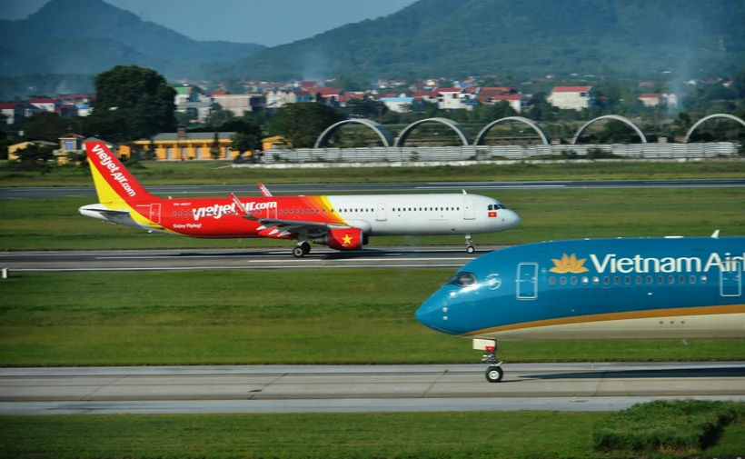 Máy bay của hai hãng hàng không Vietnam Airlines và Vietjet đang chuẩn bị cất, hạ cánh tại một sân bay. (Ảnh: PV/Vietnam+)