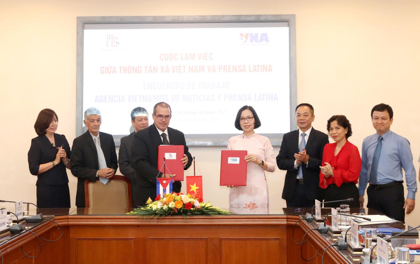 Tổng giám đốc Thông tấn xã Việt Nam Vũ Việt Trang và Chủ tịch Thông tấn xã Mỹ Latinh Prensa Latina Luis Enrique Gonzalez Acosta trao văn bản ký kết hợp tác giữa hai cơ quan. (Ảnh: Phương Hoa/TTXVN)