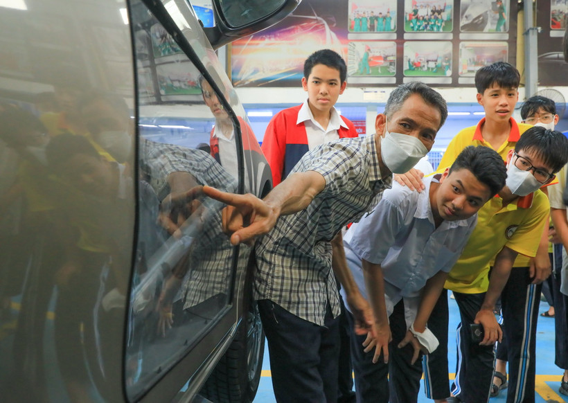 Học sinh tham quan, tìm hiểu về máy móc, ôtô tại khu xưởng sửa chữa Trường Trung cấp nghề Giao thông công chính Hà Nội. (Ảnh: Hoàng Hiếu/TTXVN)