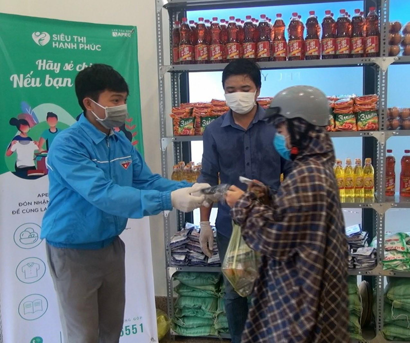 Người nghèo nhận hàng hóa và khẩu trang miễn phí. (Ảnh: Xuân Triệu/TTXVN)