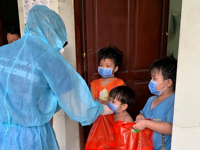 Các thanh niên tình nguyện trao quà Tết thiếu nhi cho các trẻ em trong khu cách ly tại Thuận An (Bình Dương). (Ảnh: TTXVN phát)