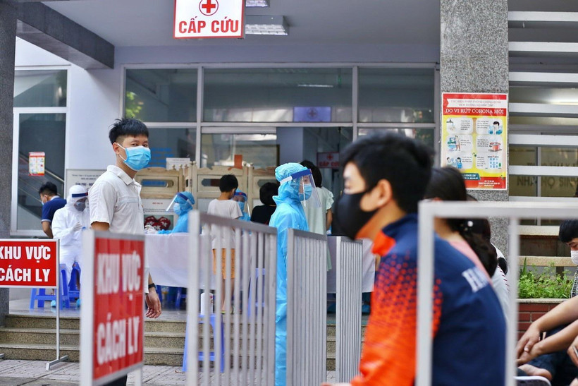 Người dân đến lấy mẫu xét nghiệm được bố trí ngồi chờ theo khu vực quy định. (Ảnh: Minh Quyết/TTXVN)