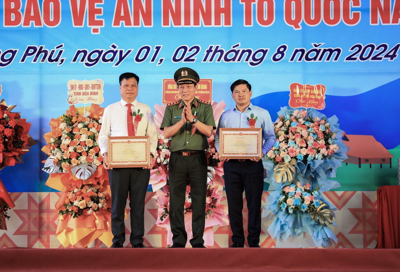 Bộ trưởng Bộ Công an Lương Tam Quang tặng Bằng khen của Bộ Công an cho đại diện tập thể nhân dân xã Phong Phú và cá nhân tiêu biểu huyện Tân Lạc. (Ảnh: Trọng Đạt/TTXVN)