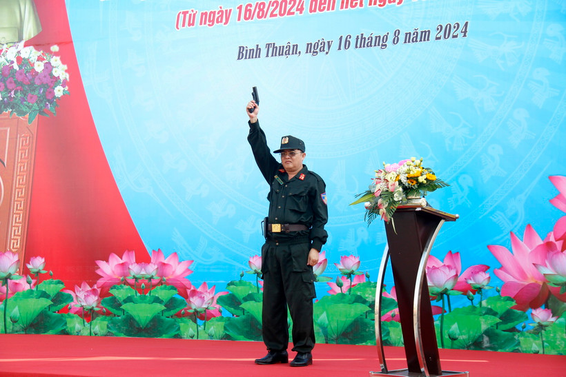 Đại tá Huỳnh Ngọc Liêm, Phó Giám đốc Công an tỉnh Bình Thuận, bắn súng phát động lễ ra quân. (Ảnh: Nguyễn Thanh/TTXVN)