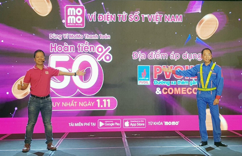Đại diện PVOIL và Ví MoMo phát động thí điểm ứng dụng thanh toán bằng ví điện tử tại cửa hàng xăng dầu. (Ảnh: Mỹ Phương/TTXVN)
