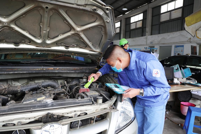 Nhân viên đăng kiểm đang thực hiện các quy trình kiểm định xe cơ giới. (Ảnh: Minh Hiếu/Vietnam+)