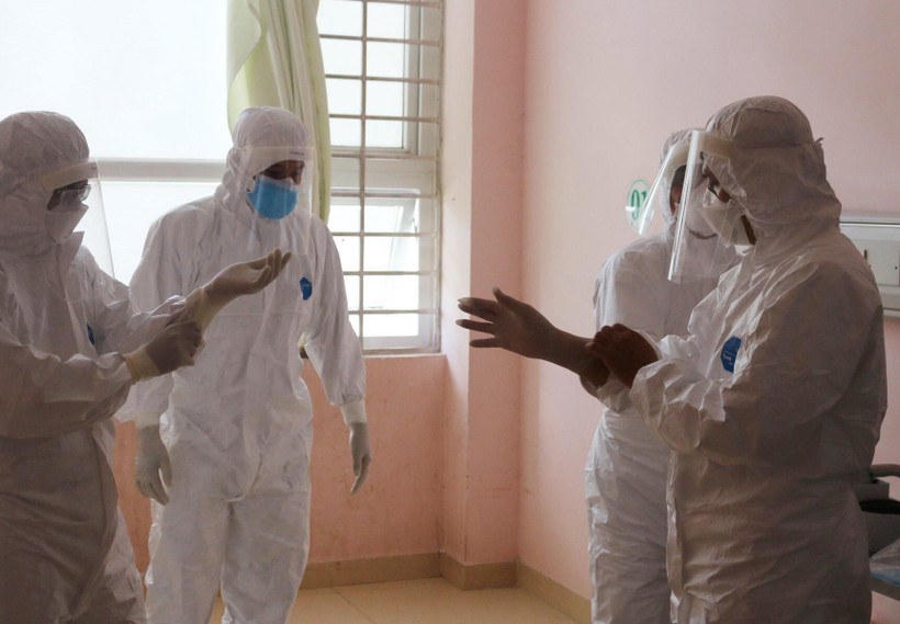  Đội phản ứng nhanh của Bệnh viện Chợ Rẫy hướng dẫn nhân viên y tế Bệnh viện Bà Rịa mặc trang phục bảo hộ. (Ảnh: TTXVN phát)