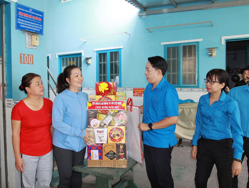 Lãnh đạo Liên đoàn Lao động Tp. Hồ Chí Minh thăm, chúc Tết chủ nhà trọ và công nhân lao động có hoàn cảnh khó khăn không có điều kiện về quê đón Tết. (Ảnh: Thanh Vũ/TTXVN)