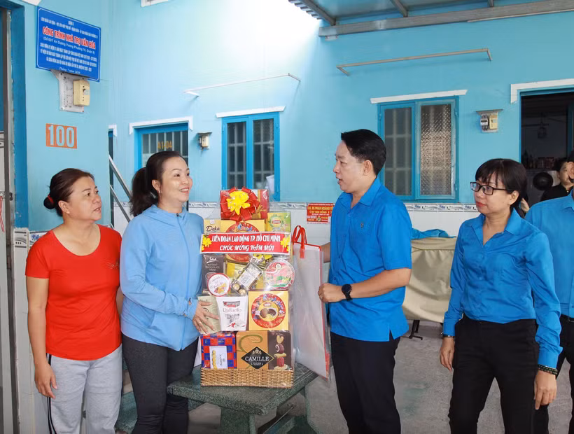Lãnh đạo Liên đoàn Lao động Tp. Hồ Chí Minh thăm, chúc Tết chủ nhà trọ và công nhân lao động có hoàn cảnh khó khăn không có điều kiện về quê đón Tết. (Ảnh: Thanh Vũ/TTXVN)