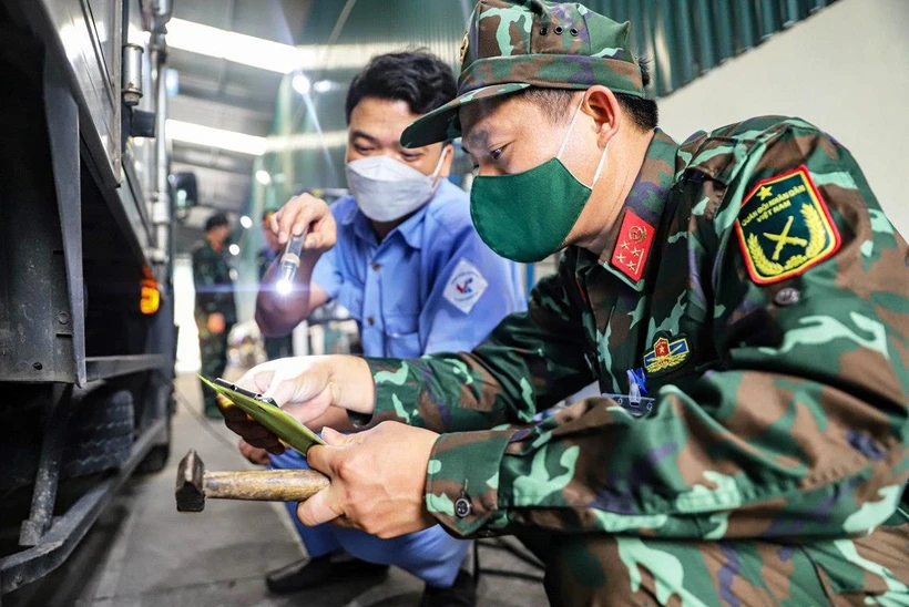 Đăng kiểm viên quân đội phối hợp với nhân viên đăng kiểm thực hiện quy trình kiểm định xe cơ giới. (Ảnh: Hoài Nam/Vietnam+)