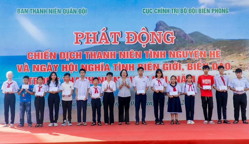 Các đại biểu tặng quà cho các cháu học sinh có hoàn cảnh khó khăn vượt khó, học giỏi. (Ảnh: Huỳnh Sơn/TTXVN)