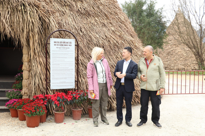 Giám đốc Sở Du lịch tỉnh Ninh Bình giới thiệu về văn hóa Tết cổ truyền của Việt Nam vào sáng mùng 1 Tết với 2 du khách đến từ Đan Mạnh. (Ảnh: Đức Phương/TTXVN)