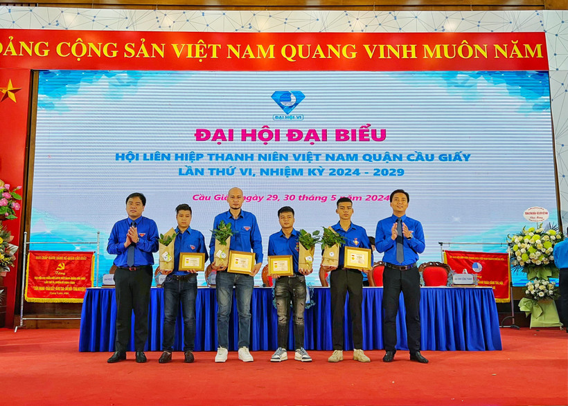 Phó bí thư thường trực Thành đoàn Hà Nội Nguyễn Đức Tiến trao Huy hiệu Tuổi trẻ dũng cảm cho 4 thanh niên cứu người trong vụ cháy tại quận Cầu Giấy. (Ảnh: PV/Vietnam+)