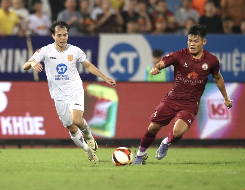 Tiền đạo Văn Toàn (Thép Xanh Nam Định) tranh chấp bóng với cầu thủ MerryLand Quy Nhơn Bình Định. (Ảnh: Công Luật/TTXVN)