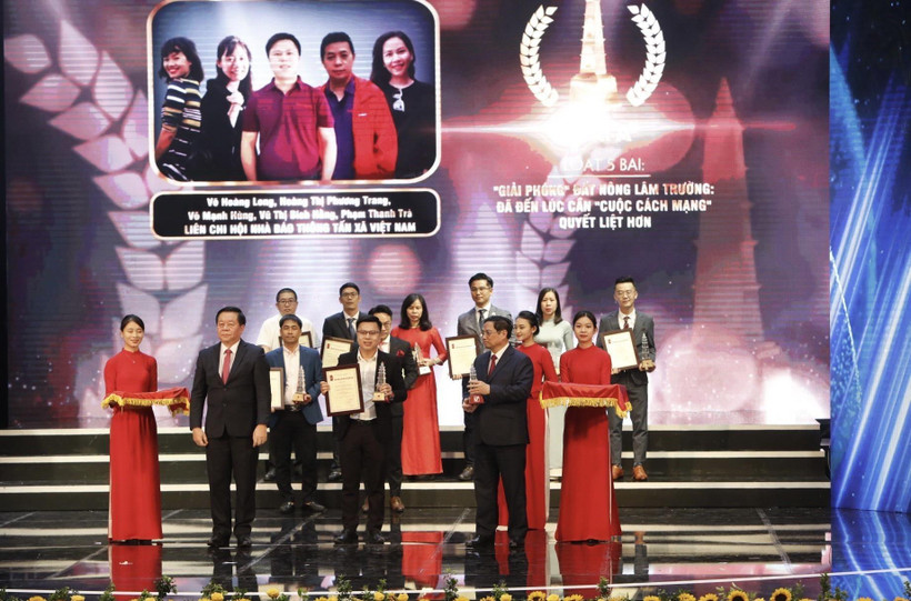 Thủ tướng Phạm Minh Chính và Bí thư Trung ương Đảng, Trưởng ban Tuyên giáo Trung ương Nguyễn Trọng Nghĩa trao giải A cho các tác giả. (Ảnh: Trần Việt/TTXVN)