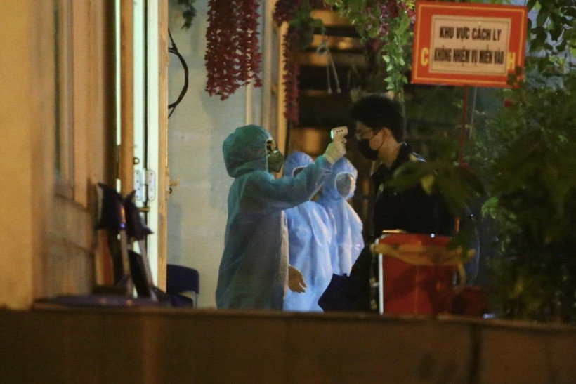 Nhân viên y tế sẽ đo thân nhiệt cho mỗi người trước khi vào khu cách ly. (Ảnh: Minh Quyết/TTXVN)