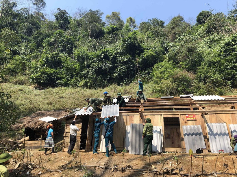 Cán bộ, chiến sỹ đồn biên phòng cửa khẩu Lóng Sập giúp người dân sửa lại nhà. (Ảnh: Hữu Quyết/TTXVN) 