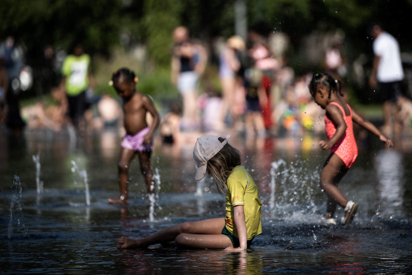 Người dân giải nhiệt tại đài phun nước ở Nantes, Pháp, khi nhiệt độ lên quá 42 độ C. (Ảnh: AFP/TTXVN)