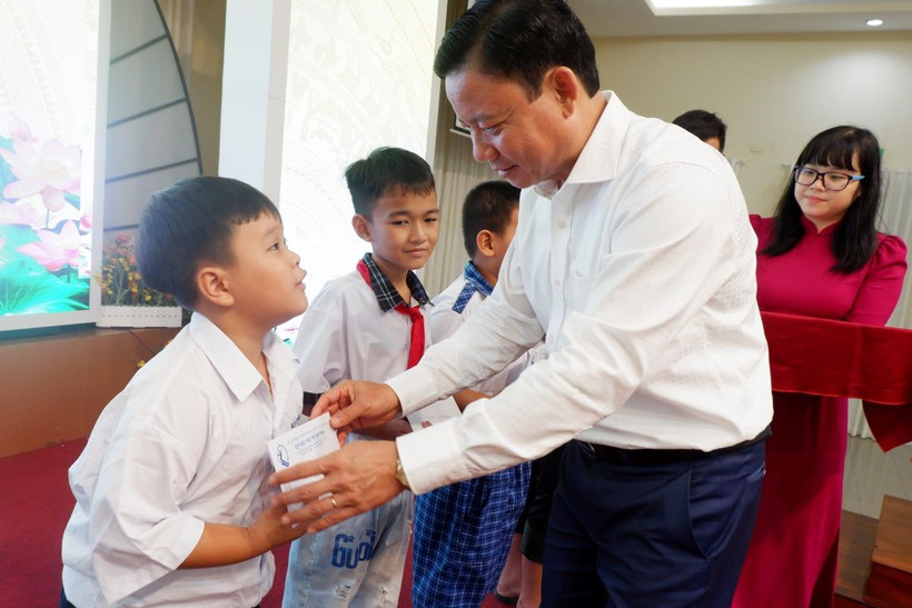 Phó Chủ tịch Ủy ban Nhân dân tỉnh Long An Phạm Tấn Hòa trao hỗ trợ cho trẻ em mồ côi do COVID-19. (Ảnh: Đức Hạnh/TTXVN)