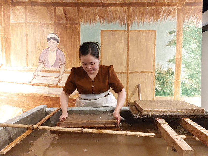 Chị Nguyễn Thị Độ đang thực hiện công đoạn xeo giấy Dó.(Ảnh: Minh Ngọc/TTXVN phát)