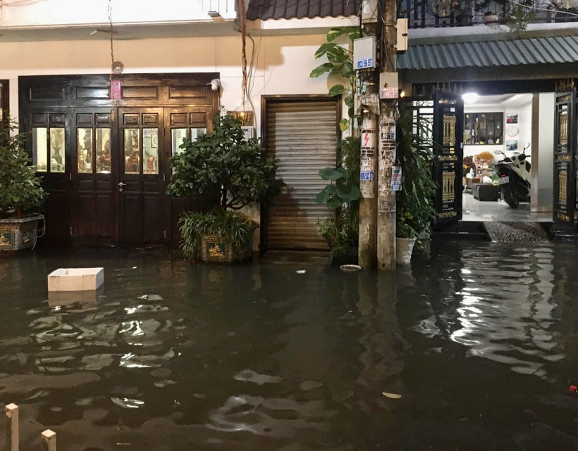 Triều cường gây nước ngập tràn vào nhà dân tại một tuyến hẻm trên đường Trần Xuân Soạn (Quận 7). ( Ảnh: Hồng Giang/TTXVN) 