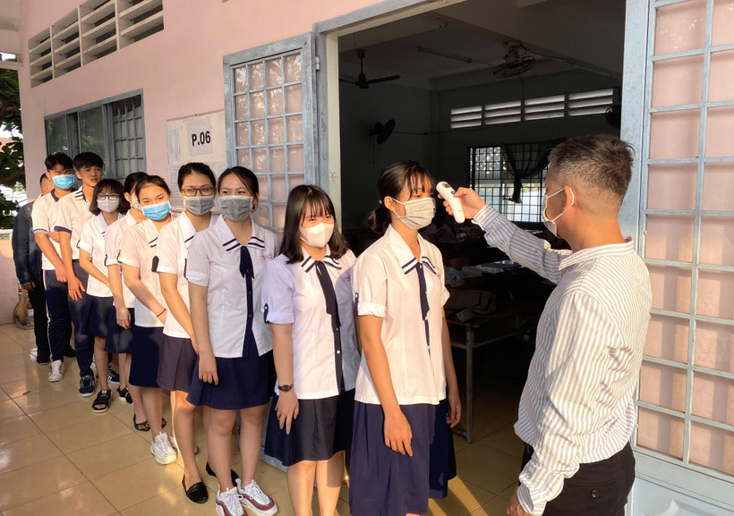 Trường THPT Vĩnh Long (thành phố Vĩnh Long, Việt Nam) đo thân nhiệt cho học sinh ngày 2/3. (Ảnh: Lê Thúy Hằng/TTXVN)