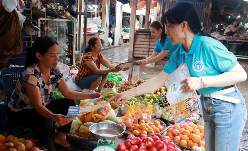 Phát tờ rơi, tuyên truyền chính sách bảo hiểm xã hội cho người dân thành phố Nam Định. (Ảnh: Nguyễn Lành/TTXVN)