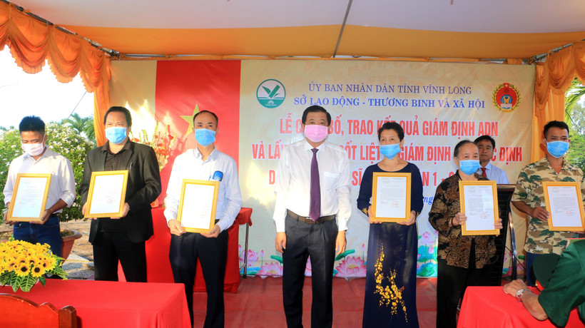 Phó Bí thư Thường trực Tỉnh ủy Vĩnh Long Bùi Văn Nghiêm trao kết quả giám định ADN xác định danh tính cho đại diện gia đình các liệt sỹ. (Ảnh: Lê Thúy Hằng/TTXVN)