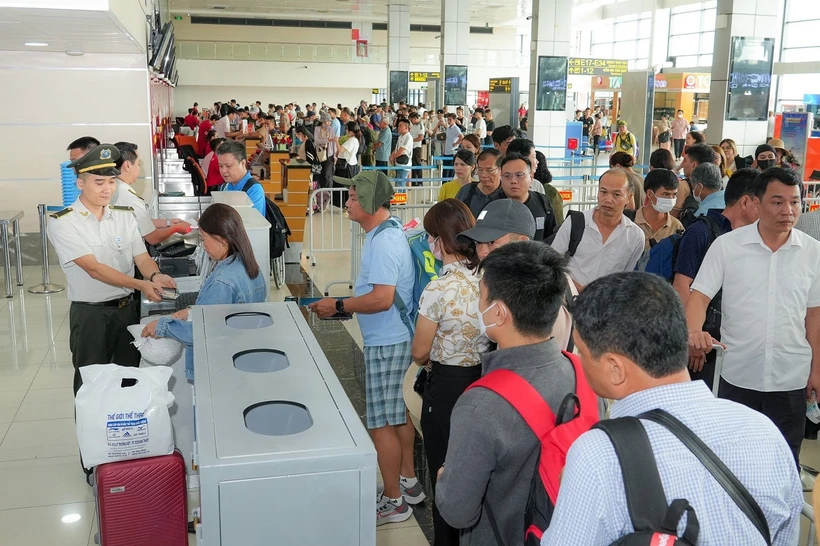 Kiểm tra giấy tờ hành khách đi máy bay trước khi vào khu vực soi chiếu an ninh. (Ảnh: PV/Vietnam+)