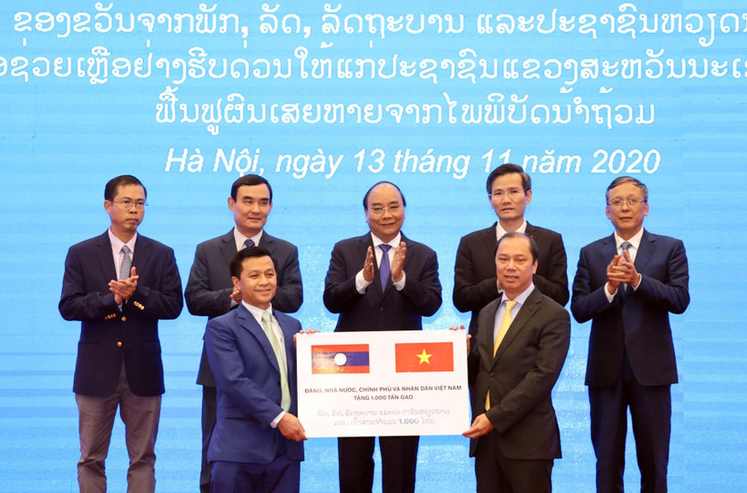 Thứ trưởng Bộ Ngoại giao Nguyễn Quốc Dũng (bên phải) trao tượng trưng 1.000 tấn gạo cho đại diện Đại sứ quán Lào tại Việt Nam trước sự chứng kiến của Thủ tướng Nguyễn Xuân Phúc. (Ảnh: Thống Nhất/TTXVN)