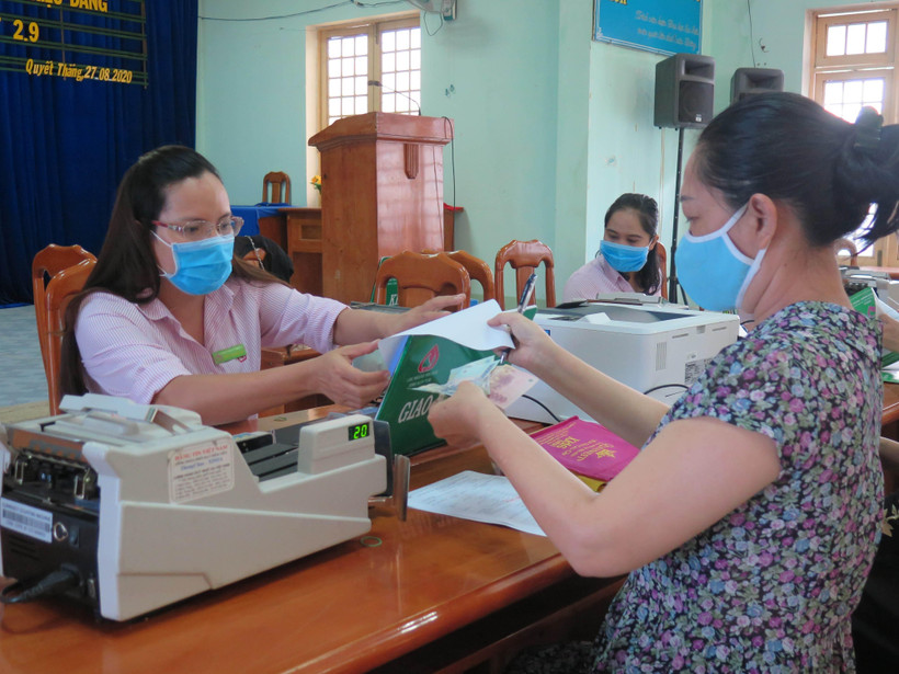 Người dân phường Quyết Thắng, thành phố Kon Tum làm thủ tục nhận tiền vay vốn tín dụng chính sách. (Ảnh: Dư Toán/TTXVN)