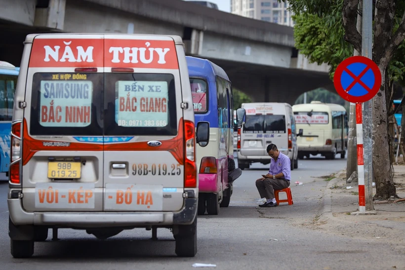 Xe hợp đồng đón trả khách ngay trước cổng khu vực Bến xe Mỹ Đình. (Ảnh: Hoài Nam/Vietnam+)