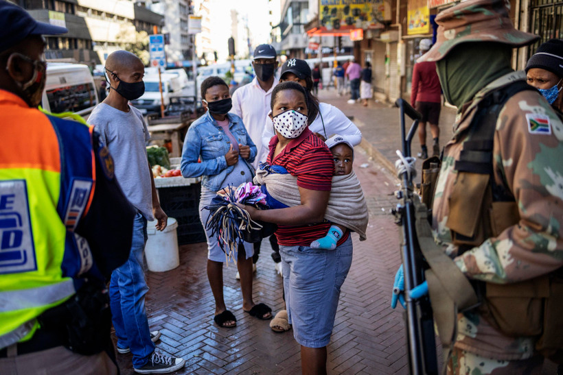 Binh sỹ Nam Phi tuần tra tại một khu chợ ở thủ đô Johannesburg để khuyến cáo người dân tránh tụ tập đông người nhằm ngăn dịch COVID-19 lây lan. (Ảnh: AFP/TTXVN)