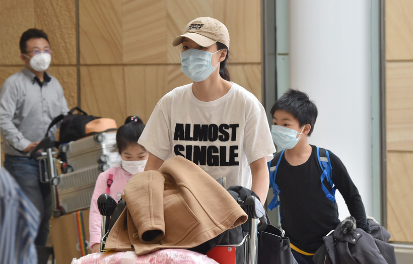 Hành khách đeo khẩu trang phòng tránh lây nhiễm virus corona tại sân bay Sydney, Australia. (Ảnh: AFP/TTXVN)