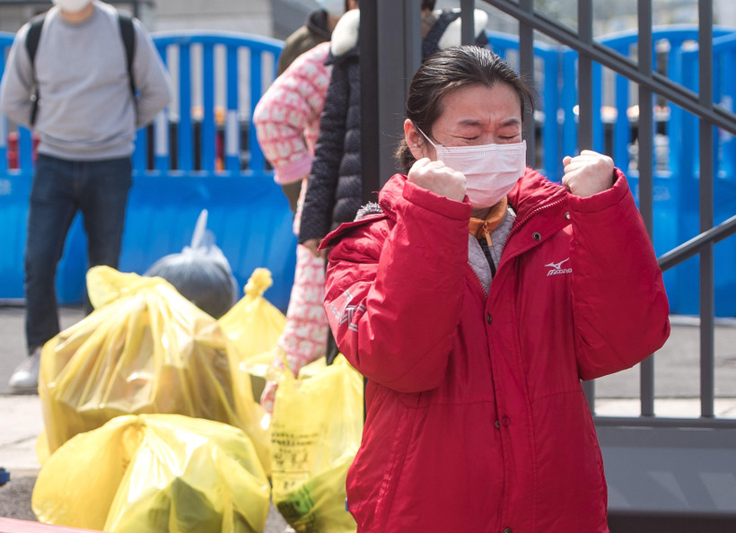 Một bệnh nhân được điều trị khỏi COVID-19 xúc động khi rời bệnh viện dã chiến ở Vũ Hán, tỉnh Hồ Bắc, Trung Quốc, ngày 8/3/2020, trước khi bệnh viện này đóng cửa. (Ảnh: THX/TTXVN)