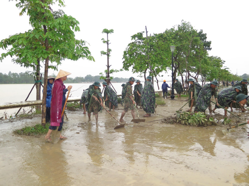 Các lực lượng dọn dẹp bùn đất tại khu vực 2 bên bờ sông Hương. (Ảnh: Tường Vi/TTXVN)